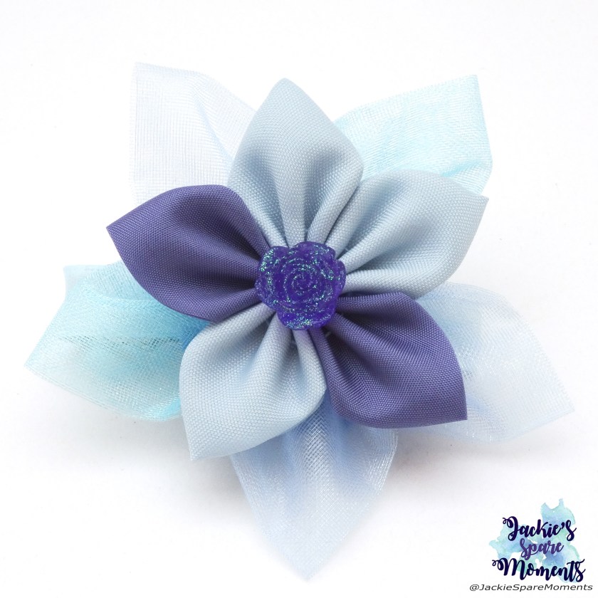 A flower made with different shades of blue and lilac organza and satin.