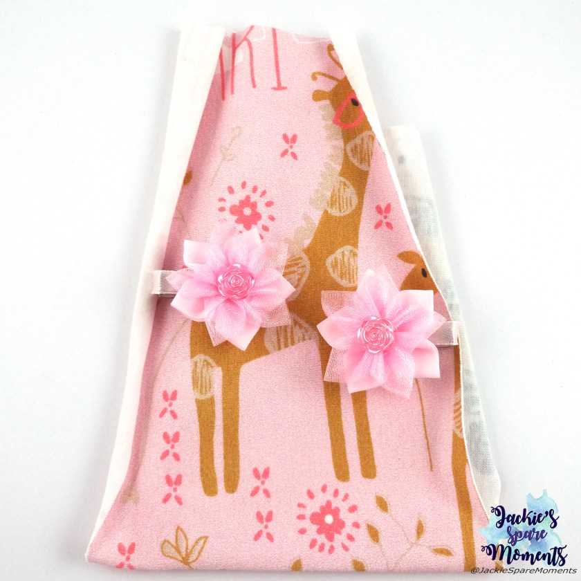 Small pink flower hair bows with flower centre flatback on the fabric off the dress