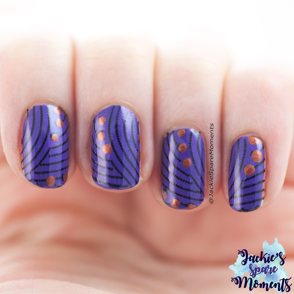 Nail art with stamped dots in black, added dots in copper on a purple base
