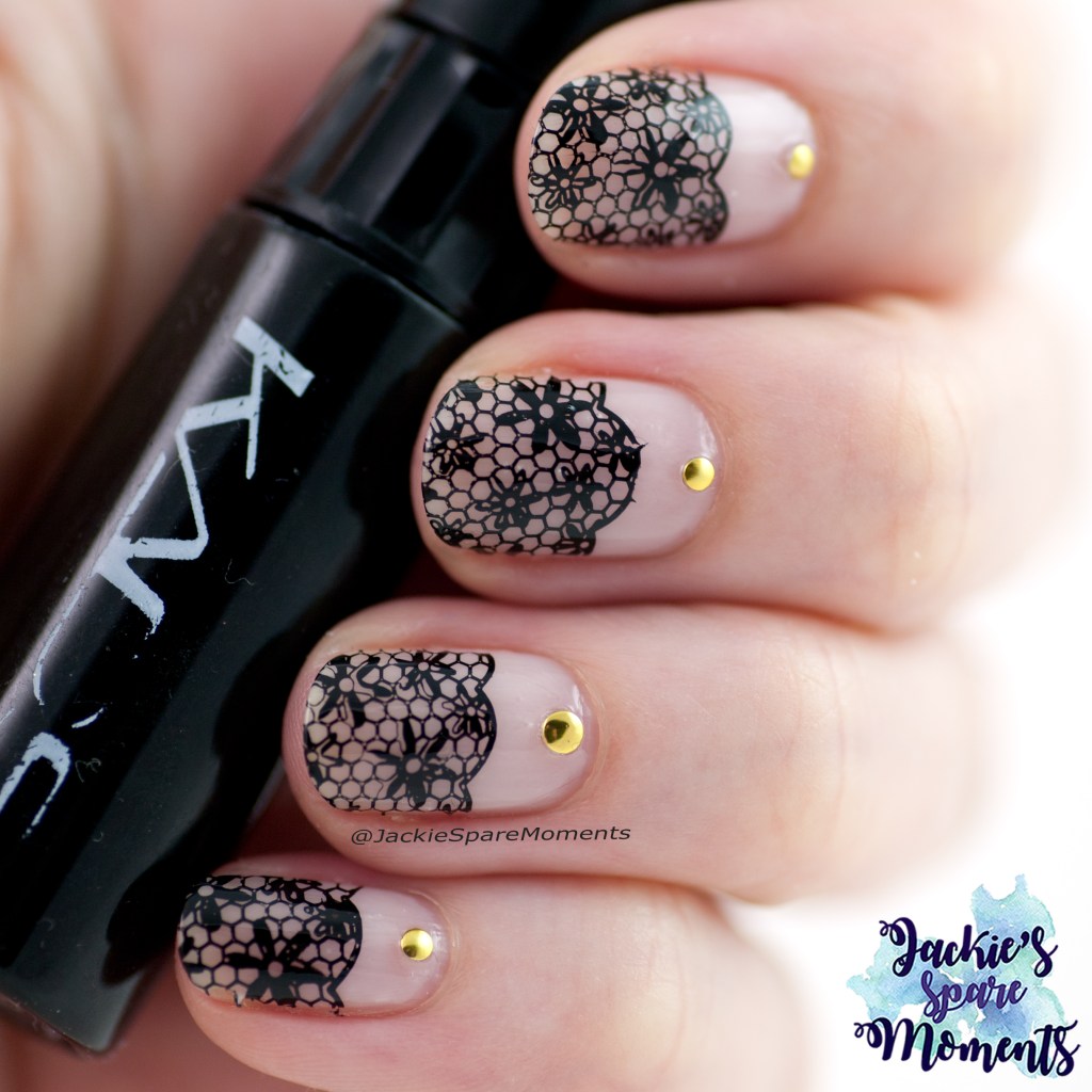 Black negative space nail art with black stamping and gold studs